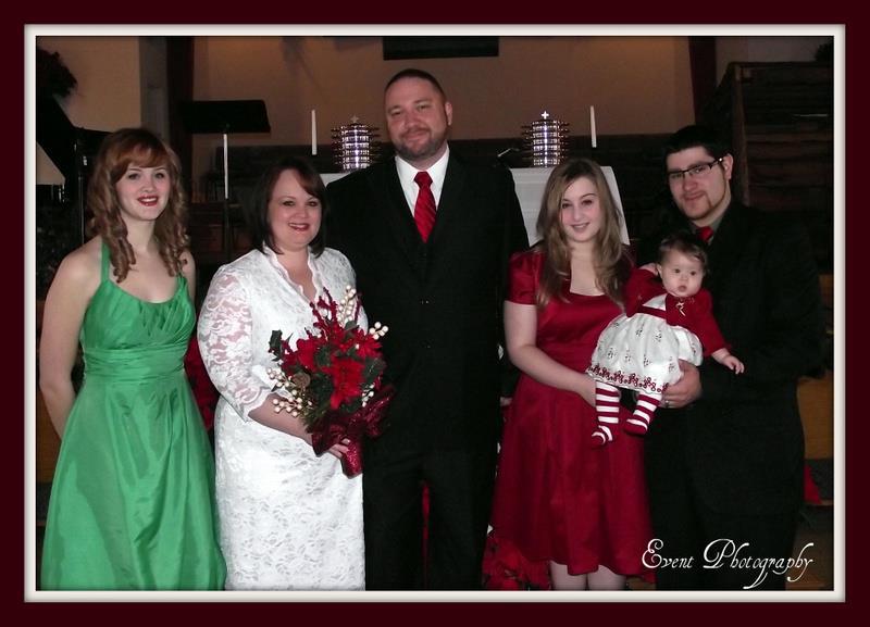 Family portrait from a small Christmas Eve wedding in 2011: Heather and Steve stand together after their ceremony, joined by their daughters Julie and Jordan, son-in-law Giovannie, and baby Bella, all dressed in festive holiday attire inside a church.